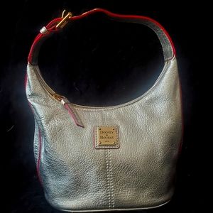 Dooney and Bourke leather metallic silver bucket purse with red leather trim.